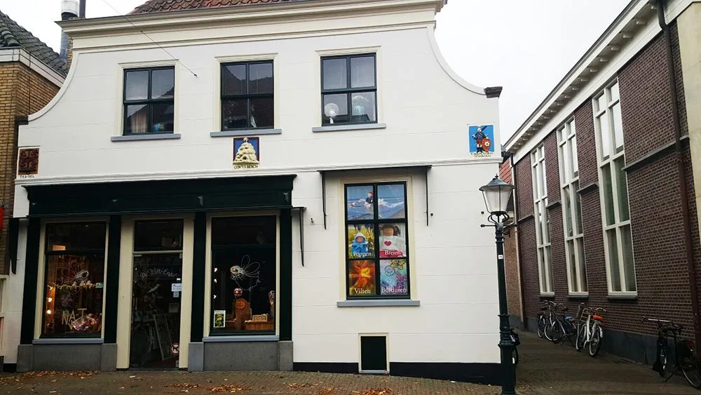 Wit winkelpand met donkergroene kozijnen, vers geschilderd